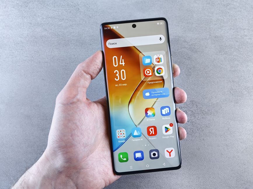 Close-up de uma mão segurando um smartphone exibindo aplicativos na tela contra um fundo texturizado.